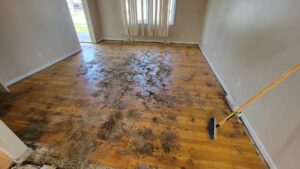 A dirty floor covered with debris inside a house, indicating an interior cleanout job by T&G Dumping in Lorain, OH.