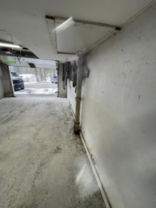 A close-up of a dirty garage floor before an epoxy coating project by Epoxy Evolution in Albany, NY.