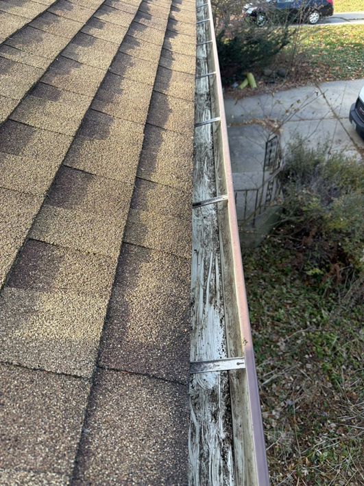 A dirty gutter filled with debris and white residue, ready for cleaning by Zamora Roofing & Construction LLC in Madison, WI.