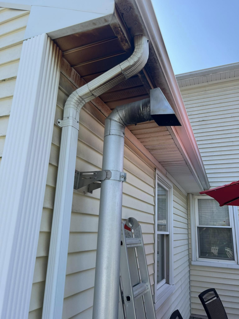 A close-up of a dirty gutter with a ladder, showing exterior cleaning work by Corriveau Home Improvement LLC in Bristol, CT.