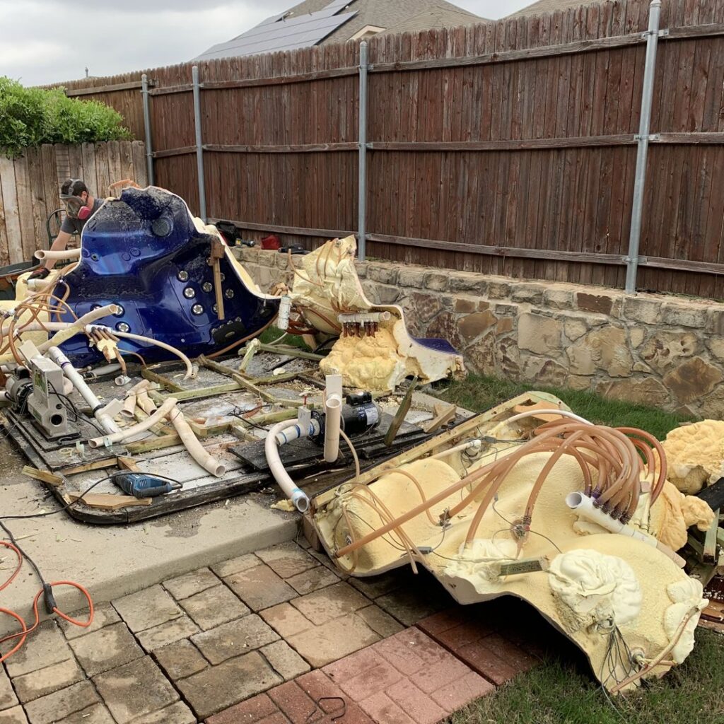 Disassembled hot tub parts and debris in a backyard, being prepared for removal by NTX Haul Away Junk Removal in Fort Worth, TX.