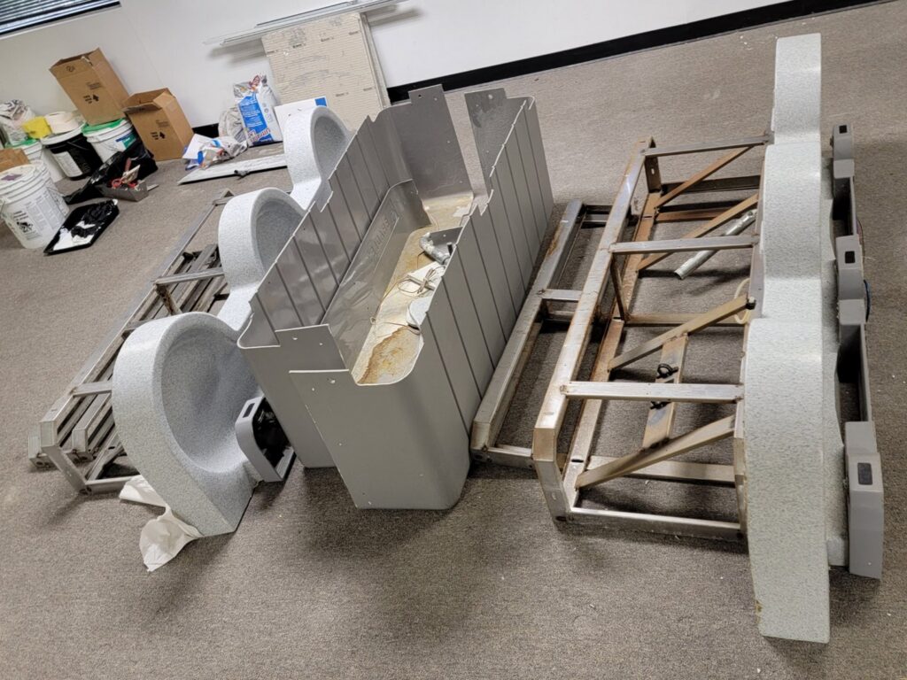 Disassembled large metal structures on a carpeted floor, ready for commercial junk removal by DUMP 4 U Hauling in Jacksonville, FL.