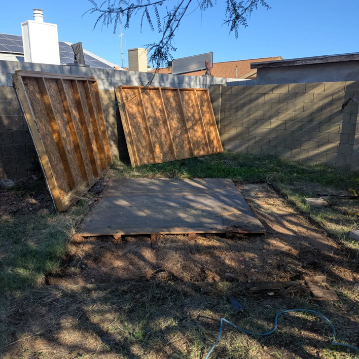 Disassembled shed walls and base in a backyard, ready for junk removal by J & R Junk Removal in Phoenix, AZ.