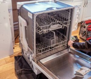 A dishwasher pulled out from the cabinet with its side panel removed for repair by Appliance Handyman of Twin Falls, ID
