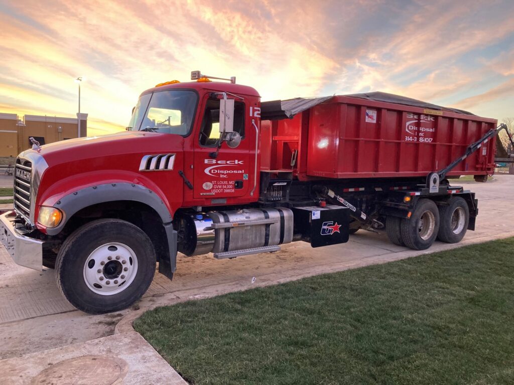 A Beck Disposal Inc. truck with a roll-off dumpster parked at sunset in St. Louis, MO