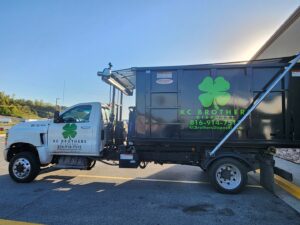A KC Brothers Disposal truck with a black dumpster on its bed, ready for junk removal in Kansas City, MO.