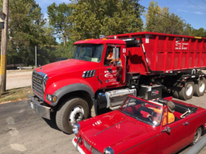A Beck Disposal Inc. truck with a roll-off dumpster driving on a street in St. Louis, MO