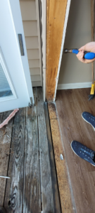 A handyman performing wood repair on a door frame, part of property services by Ray's Property Services in Johnson City, TN