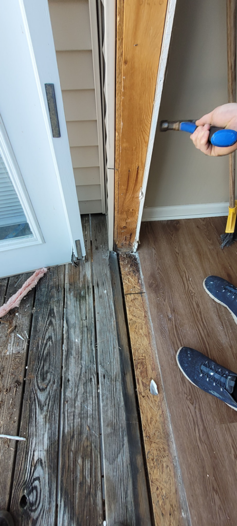 A handyman performing wood repair on a door frame, part of property services by Ray's Property Services in Johnson City, TN