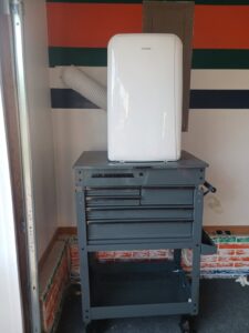 A new single cylinder deadbolt package held in front of a door with an existing lock, indicating installation or repair by Cedar Rapids On Call Handyman Service in Cedar Rapids, IA