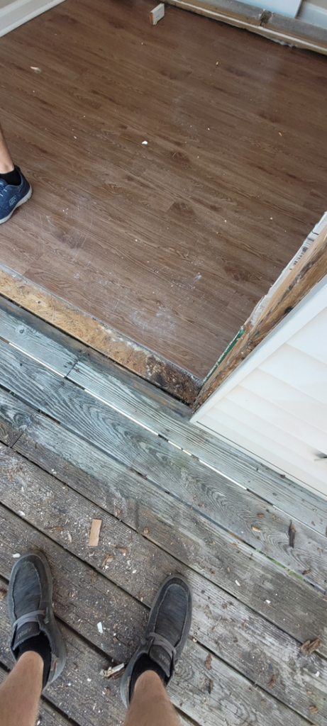 Door threshold and floor transition area under repair, showing new flooring and deck work by Ray's Property Services in Johnson City, TN