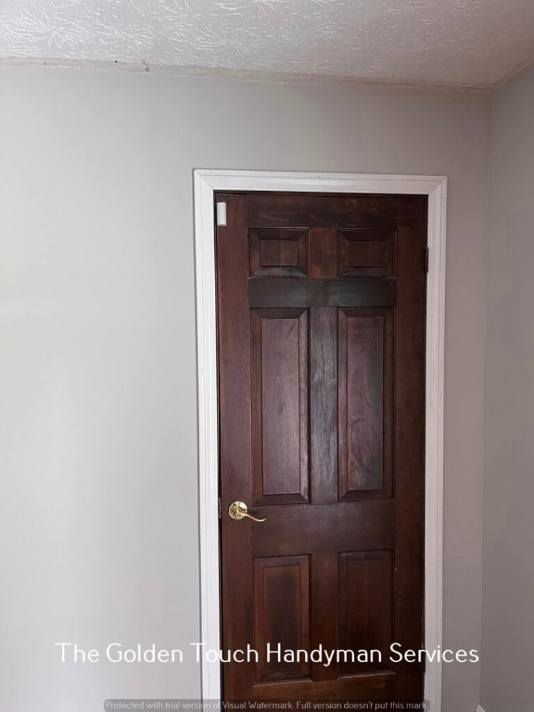 A newly painted door and trim, showcasing painting services by The Golden Touch handyman services in Huntington, WV.