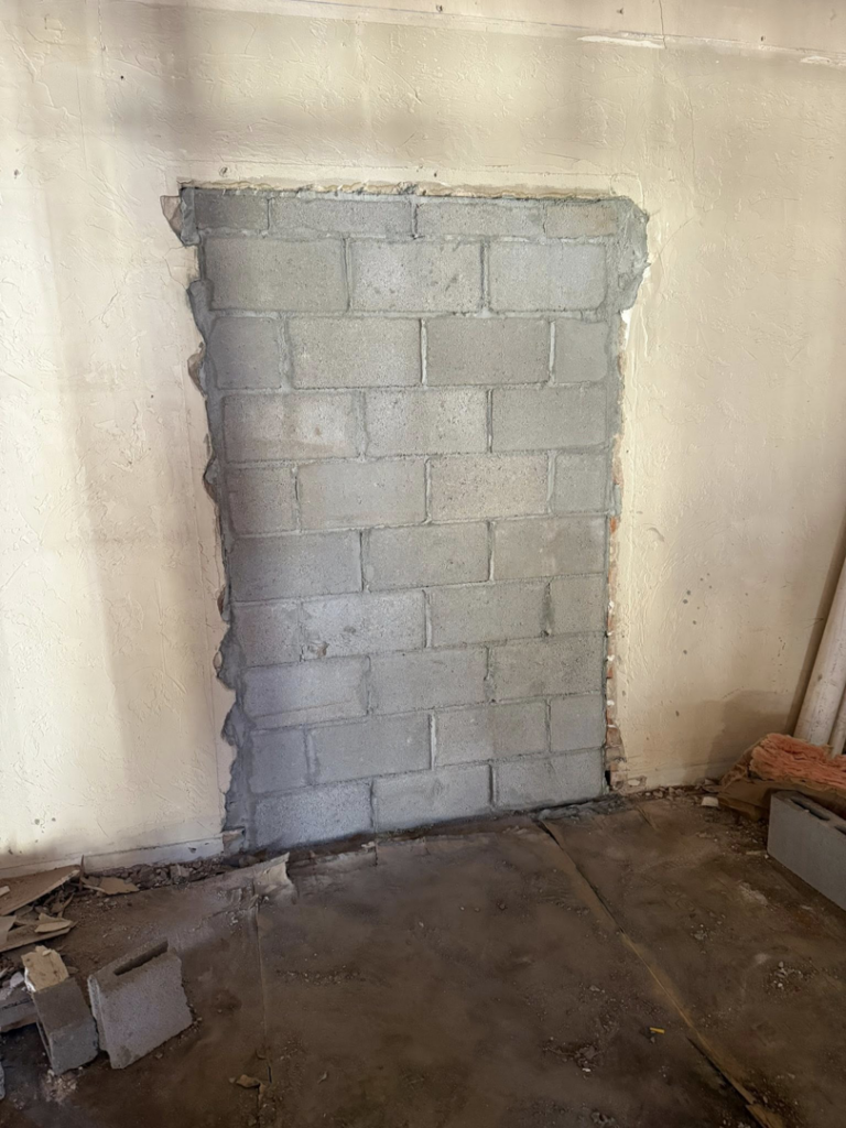 A doorway opening expertly filled with concrete blocks (CMU) as a completed masonry job by Milflores King Construction LLC in Glendale, AZ