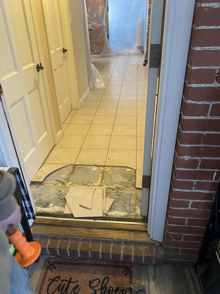 Doorway tile replacement in progress, showing old and new flooring by Main Street Handyman, LLC in Winter Garden, FL.