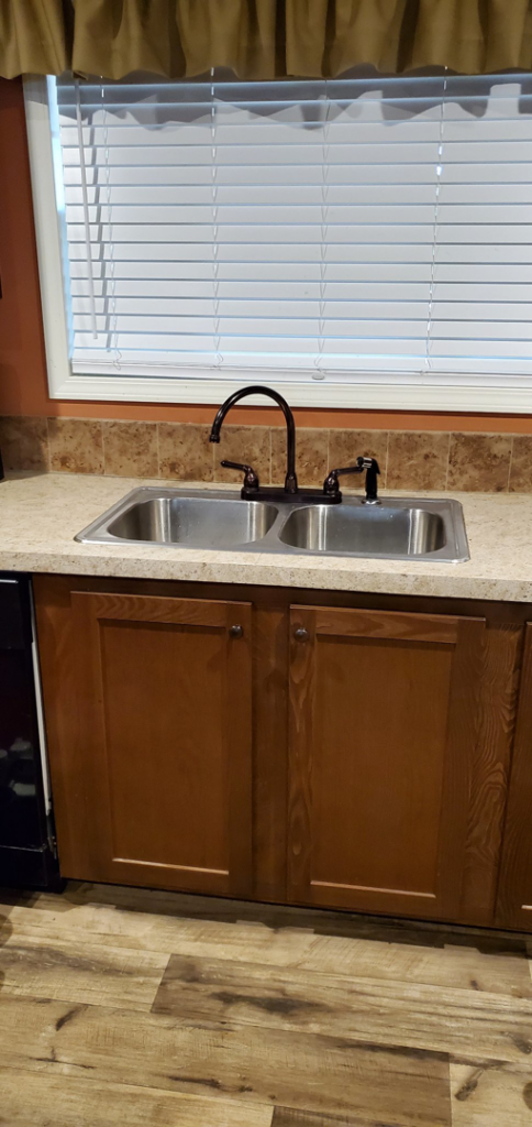 A newly installed double-basin kitchen sink and faucet by Walnut Bridge Construction in Knoxville, TN