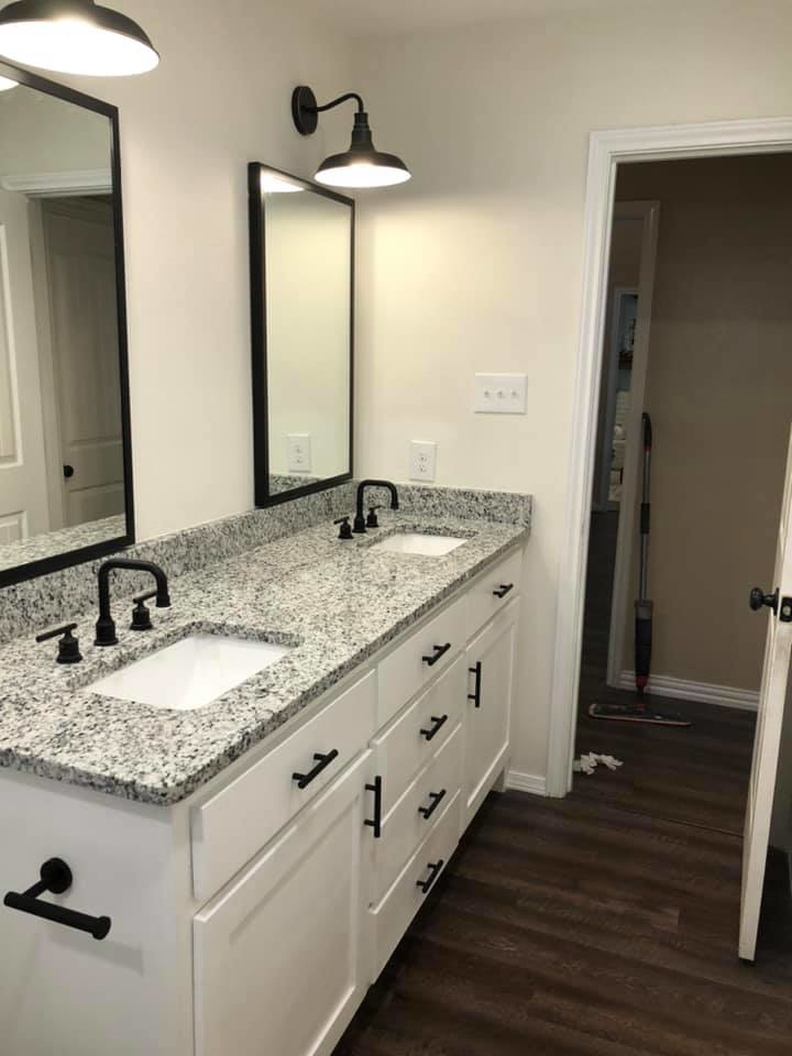 A double bathroom vanity with granite countertops and black fixtures installed by Mason Contracting in Levittown, PA.