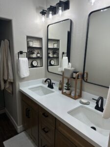 A newly installed double bathroom vanity with black fixtures and mirrors by Centennial Builders, LLC in Litchfield Park, AZ.