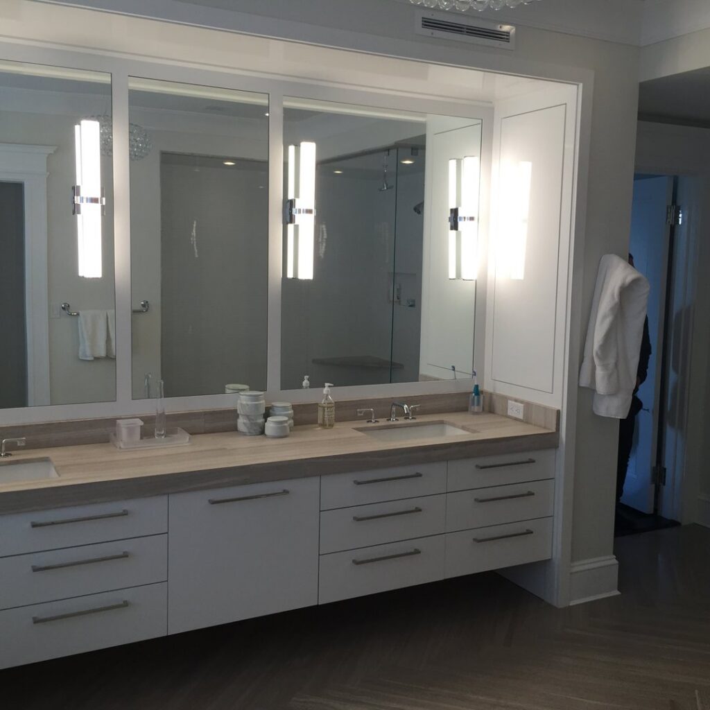 A modern double bathroom vanity with large mirrors and lighting installed by Connaughton Construction in Waltham, MA
