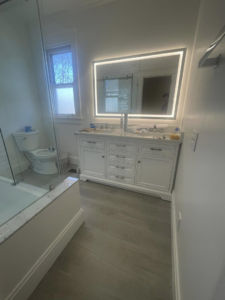 A newly installed double bathroom vanity with an illuminated mirror by Anderkin Remodeling in Cincinnati, OH