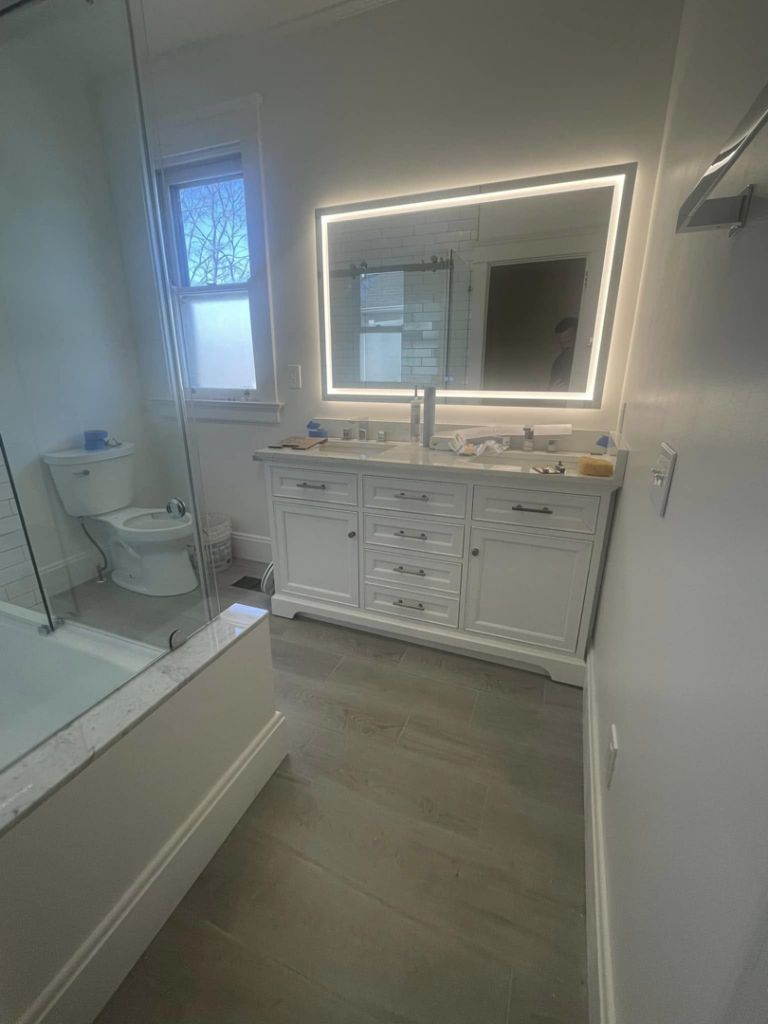 A newly installed double bathroom vanity with an illuminated mirror by Anderkin Remodeling in Cincinnati, OH