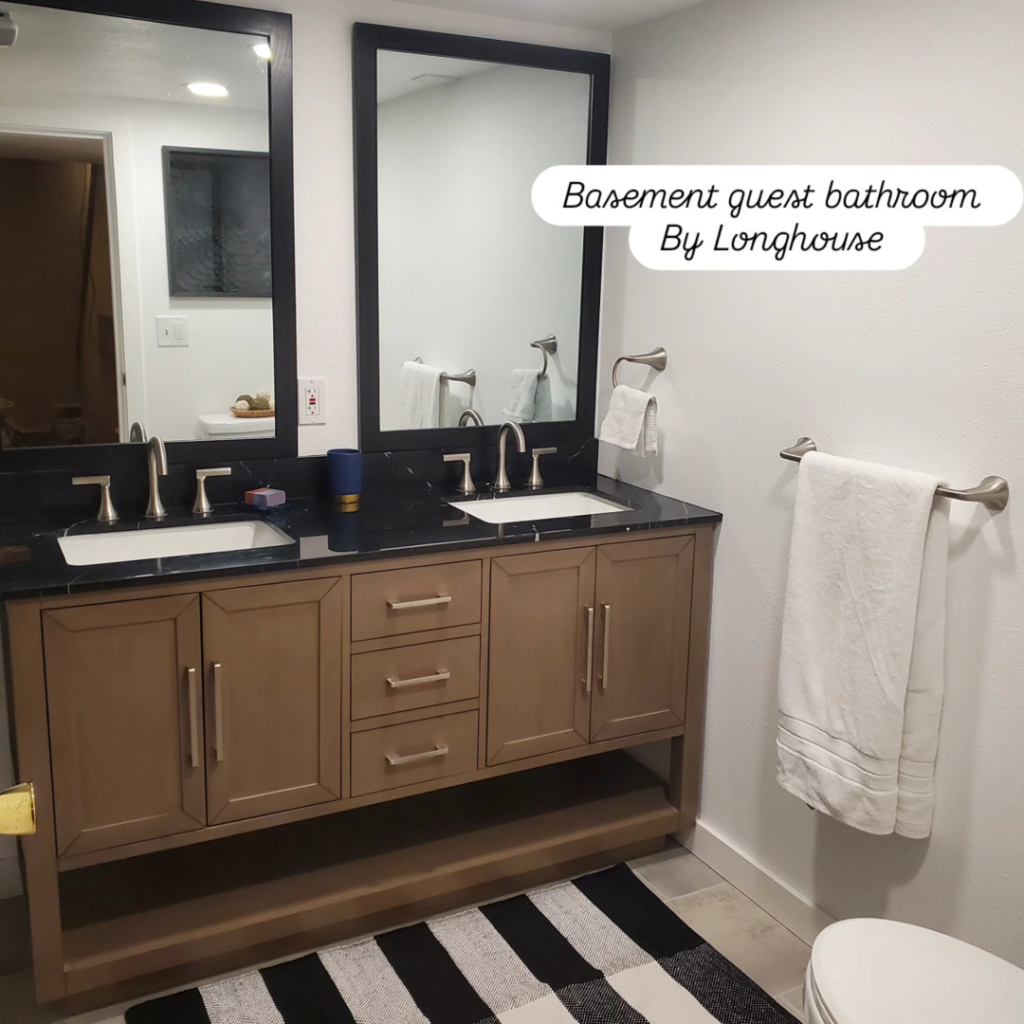 A newly installed double-sink vanity and mirrors in a basement guest bathroom by Longhouse Construction Inc. in Estacada, OR.