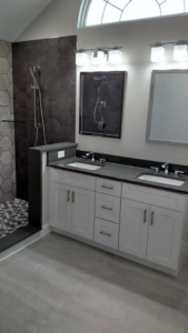 Renovated bathroom with a double vanity and modern walk-in shower by Coastal Contracting Services Inc., Virginia Beach, VA.