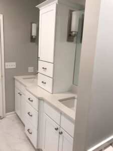 A bathroom remodel featuring a double vanity with white cabinets and a tall storage unit by FEARS Construction in Nashville, TN.