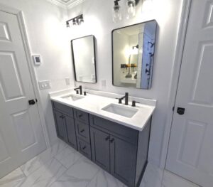 A double vanity bathroom remodel featuring dark cabinets and white countertops by Stanley Contracting in Whiting, NJ
