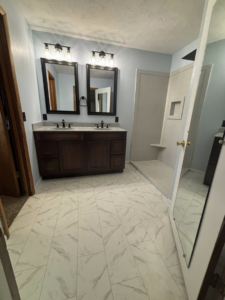 A modern bathroom remodel featuring a double vanity and walk-in shower by Craft Tile Co in Springfield, MO.