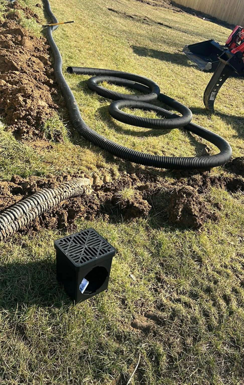 Drainage pipe installation in a trench with a drain box by Tharp's Roofing & Construction in Owensboro, KY.