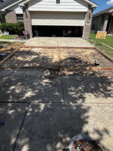 A residential driveway area prepped with rebar and wooden forms for concrete pouring by All Aboard Contractors in Houston, TX.