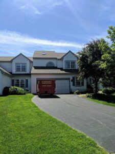 A red dumpster from Affordable Dumpsters placed in a residential driveway in Watervliet, NY.