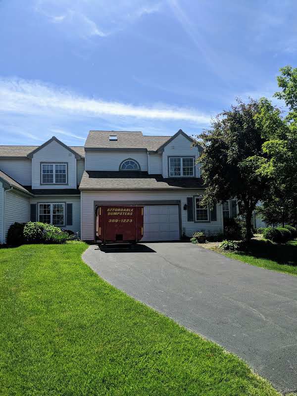 A red dumpster from Affordable Dumpsters placed in a residential driveway in Watervliet, NY.