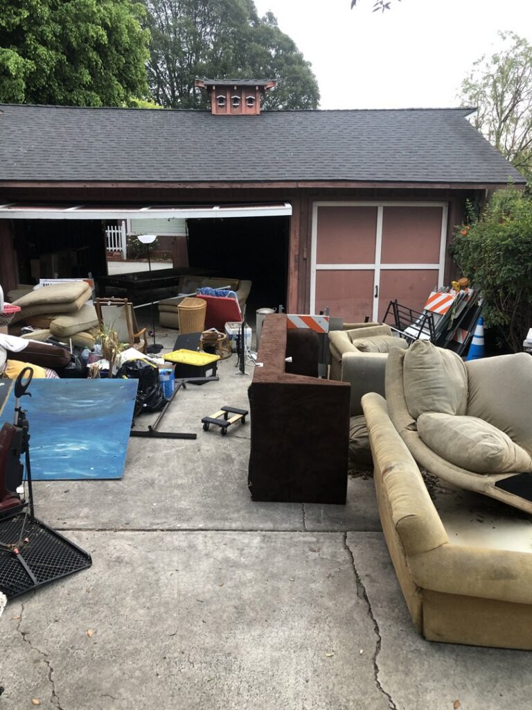 A driveway overflowing with old furniture and household junk ready for removal by The Junk Gentlemen in Anaheim, CA.