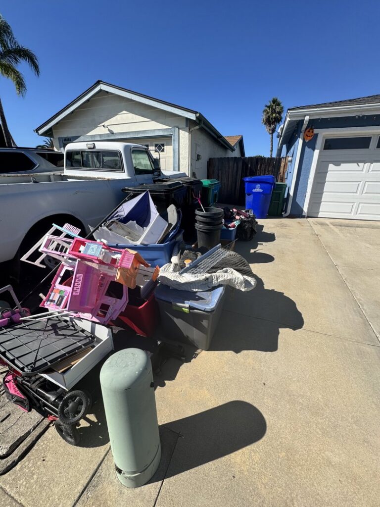 Large pile of household junk and clutter on a driveway ready for Johan's Junk Removal and Hauling in San Diego, CA