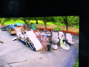 An aerial view of a driveway with a large pile of patio furniture and various junk items ready for removal by CC JUNK Removal in Corpus Christi, TX.