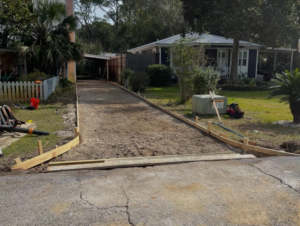 Driveway area prepared with wooden forms for new concrete pouring by Unified Roofing and Exteriors in Gulf Shores, AL.