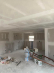 Interior room showing drywall finishing work with materials on the floor by R&R Foundation and remodeling in Owensboro, KY