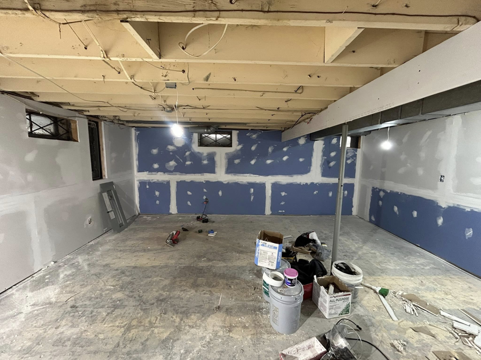 Drywall finishing and painting preparation in a basement by Pinnacle Roofing & Construction LLC in Elkhart, IN.