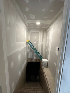 A staircase area undergoing drywall finishing and mudding by A Bit Of Everything LLC in Cranston, RI.