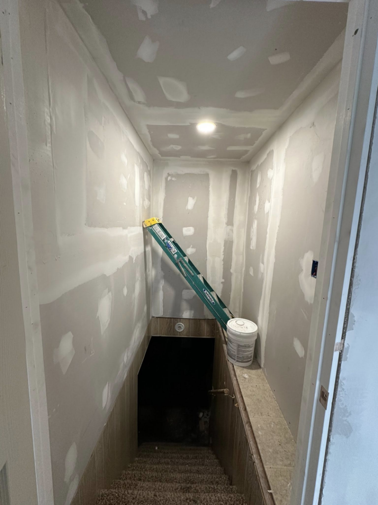 A staircase area undergoing drywall finishing and mudding by A Bit Of Everything LLC in Cranston, RI.