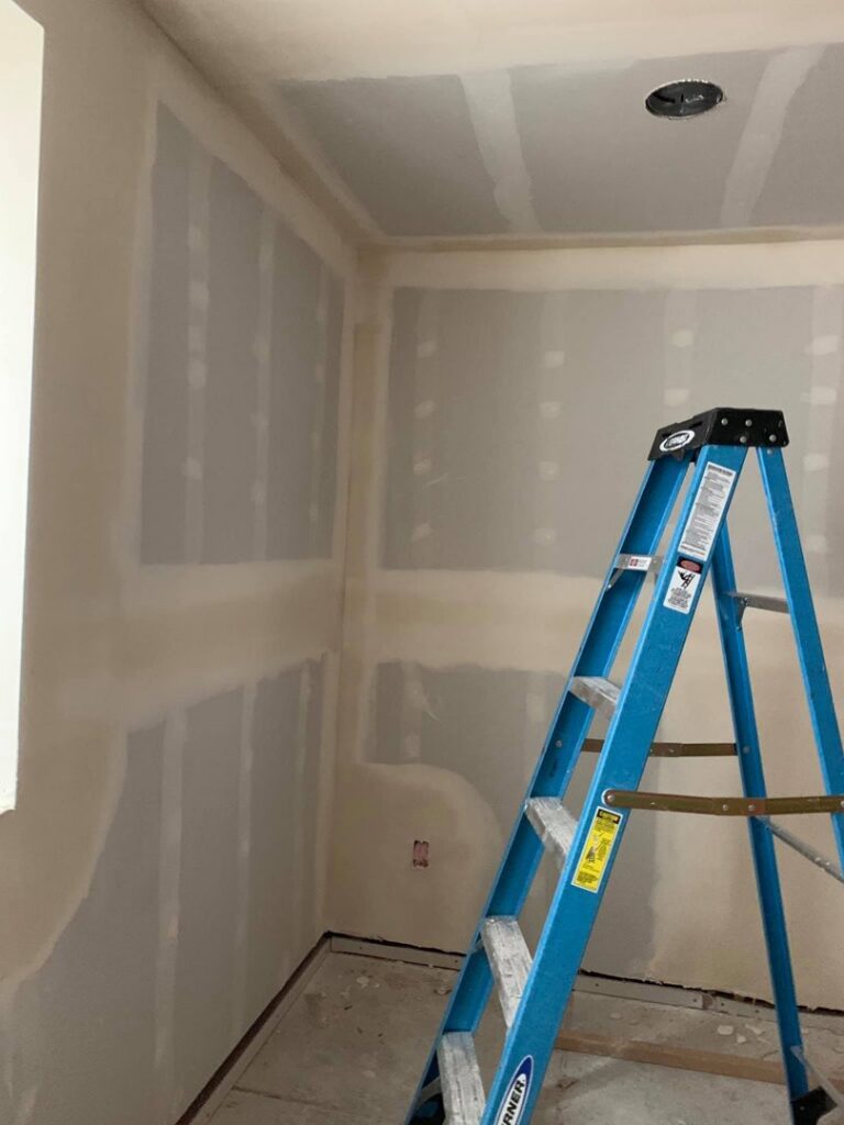 Interior view of a room with new drywall installed and taped, ready for finishing by Vazquez Quality Construction Inc in Aurora, CO.