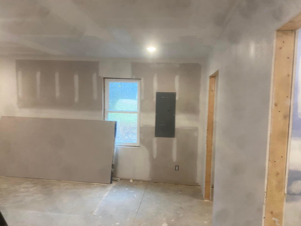 New drywall installed and taped in a room with an electrical panel by R&R Foundation and remodeling in Owensboro, KY