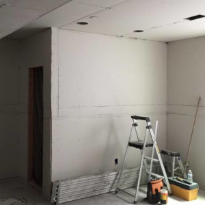 Drywall installation and finishing in progress with tools in a room by Continental Drywall in Aurora, CO