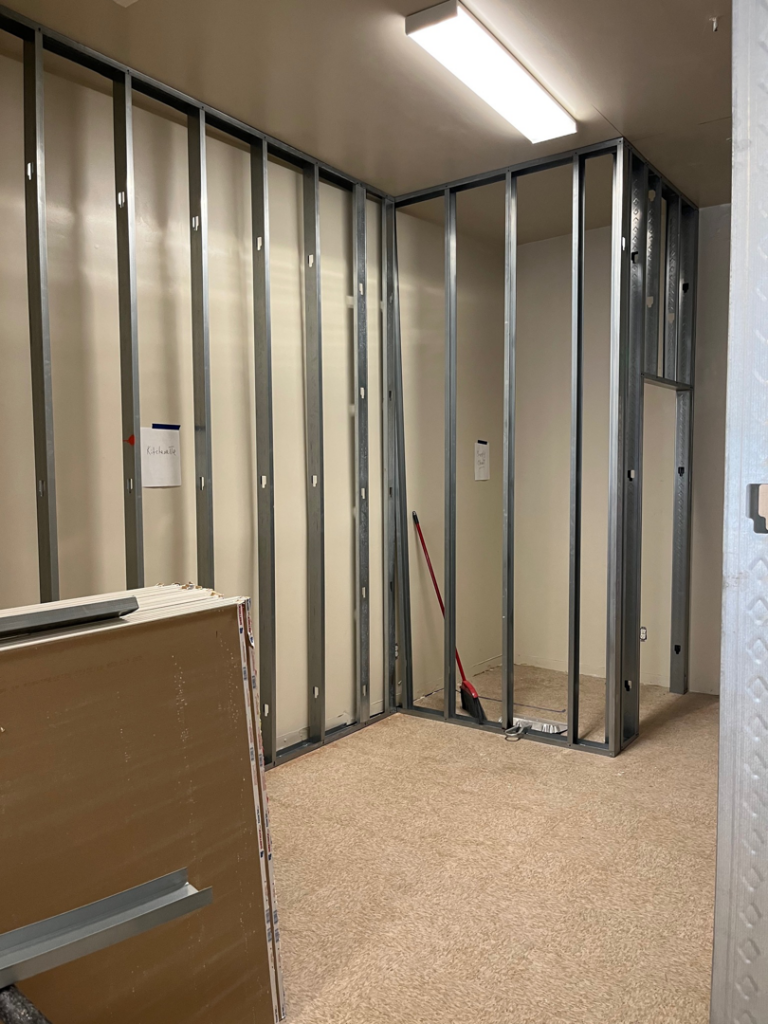 Drywall sheets ready for installation on metal studs during a commercial project by Pharos Contracting Company Inc. in Newark, NJ