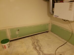 Drywall installation in progress in a room, showing green board panels ready for finishing by Amazing Handyman Services in West Fargo, ND