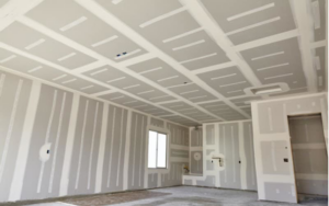 A room with newly installed and taped drywall on walls and ceiling, ready for finishing by Rapid Response Crew in Charlotte, NC.