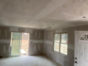 Interior room with new drywall, a sliding door, and front door installed by R&R Foundation and remodeling in Owensboro, KY