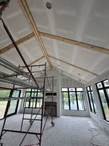 Drywall installation in progress on walls and a vaulted ceiling with scaffolding by Hahn Brothers Drywall Co Inc in Evansville, IN