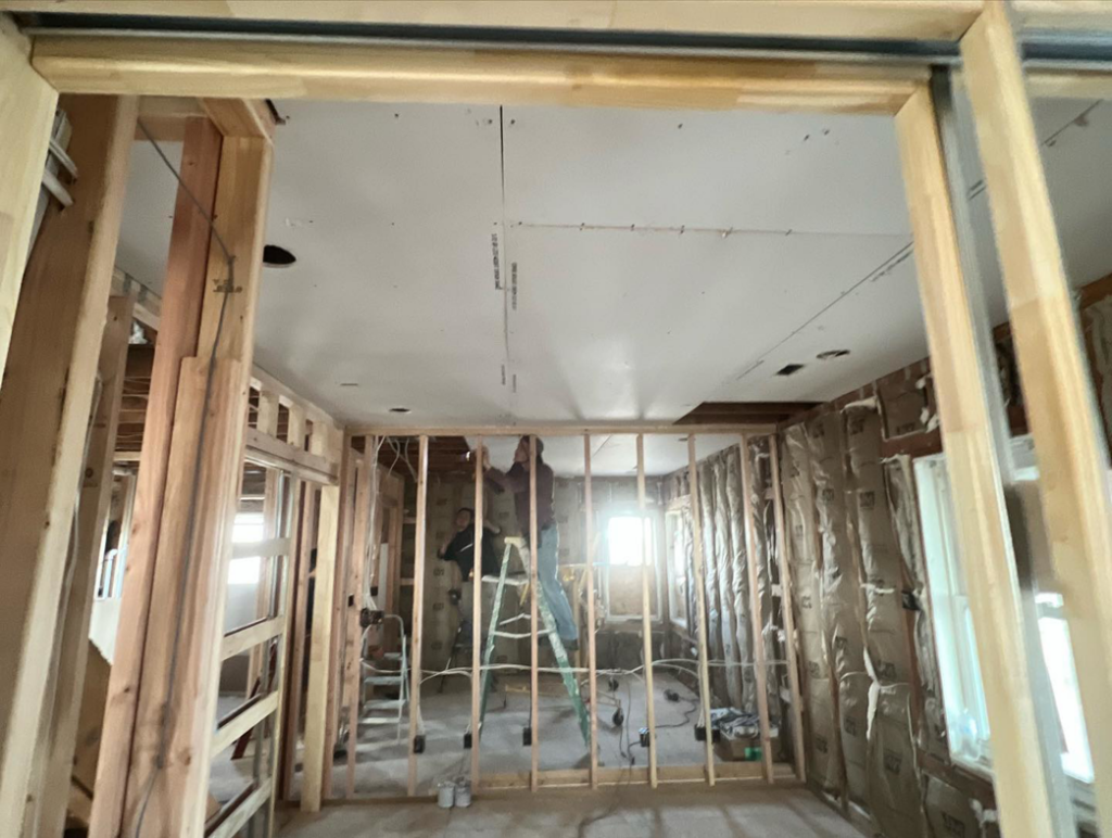 Two workers installing drywall on a ceiling during a renovation project by Kliesen Construction Company in Pueblo, CO.